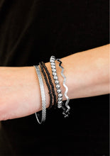 Load image into Gallery viewer, Varying in shimmer and shine, two silver bangles join a mishmash of stretchy silver and black beaded bracelets around the wrist for a seasonal look.  Sold as one set of five bracelets.   