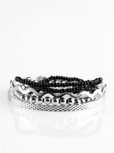 Load image into Gallery viewer, Varying in shimmer and shine, two silver bangles join a mishmash of stretchy silver and black beaded bracelets around the wrist for a seasonal look. Sold as one set of five bracelets.