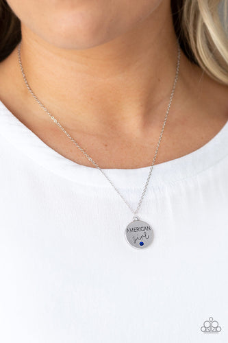 Dotted with a dainty blue rhinestone, a shimmery disc is stamped in the phrase, 