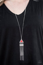 Load image into Gallery viewer, Chiseled into an alluring triangle, a fiery red stone is pressed into a studded silver frame. Embossed in tribal inspired patterns, a shimmery silver frame swings from the bottom of the colorful stone, giving way to a shimmery chain fringe for a wanderlust finish. Features an adjustable clasp closure.  Sold as one individual necklace. Includes one pair of matching earrings.  Always nickel and lead free.