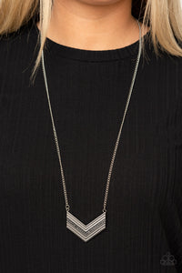 Ribbed in linear texture, the center of a stacked silver chevron-like pendant is encrusted in a row of smoky hematite rhinestones for a glitzy finish. Features an adjustable clasp closure.  Sold as one individual necklace. Includes one pair of matching earrings.  Always nickel and lead free.