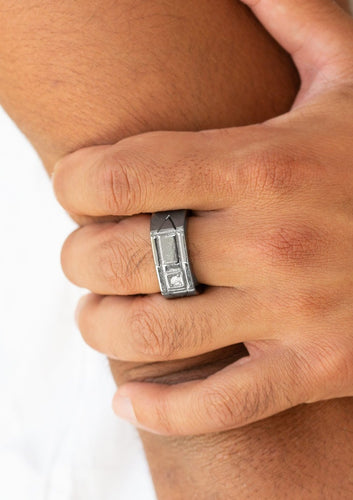 A glassy white rhinestone is pressed into the corner edge of a geometric stamped rectangular gunmetal frame. Features a stretchy band for a flexible fit.  Sold as one individual ring.  Always nickel and lead free.