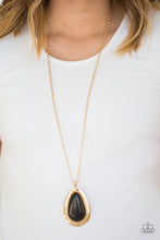 Load image into Gallery viewer, A dramatic black stone teardrop is pressed into a glistening gold frame radiating with rustic patterns. The impressive pendant swings from the bottom of a lengthened gold chain for a seasonal look. Features an adjustable clasp closure.  Sold as one individual necklace. Includes one pair of matching earrings.  Always nickel and lead free.