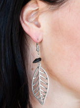 Load image into Gallery viewer, An airy silver leaf swings from the bottom of a shiny black pebble, creating a seasonal lure. Earring attaches to a standard fishhook fitting.  Sold as one pair of earrings. 