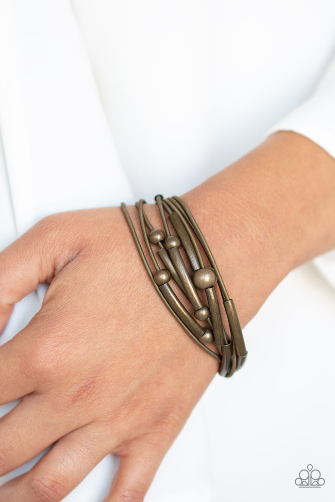 A collection of brass beads and brass accents slides along brass spring-like bracelets, creating stretchy layers around the wrist. Features a magnetic closure.  Sold as one individual bracelet.  Always nickel and lead free.