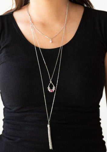 A solitaire pink pearl swings from the uppermost chain, giving way to a teardrop pendant and shimmery silver chain tassel. Dainty white rhinestones and pink pearls collect at the bottom of the centermost pendant for a glamorous finish. Features an adjustable clasp closure.  Sold as one individual necklace. Includes one pair of matching earrings.  Always nickel and lead free.