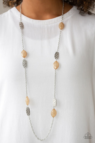 Featuring an opaque finish, glassy brown beads join hammered silver frames along a shimmery silver chain, creating a colorful collision across the chest. Features an adjustable clasp closure.  Sold as one individual necklace. Includes one pair of matching earrings.  Always nickel and lead free.