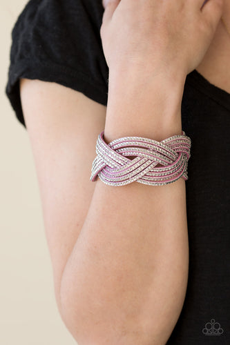 Glassy white rhinestones are encrusted along crisscrossing strands of purple suede, creating bold shimmer around the wrist. Features an adjustable snap closure.  Sold as one individual bracelet.  Always nickel and lead free.