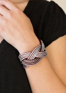 Glassy white rhinestones are encrusted along crisscrossing strands of red suede, creating bold shimmer around the wrist. Features an adjustable snap closure.  Sold as one individual bracelet.  