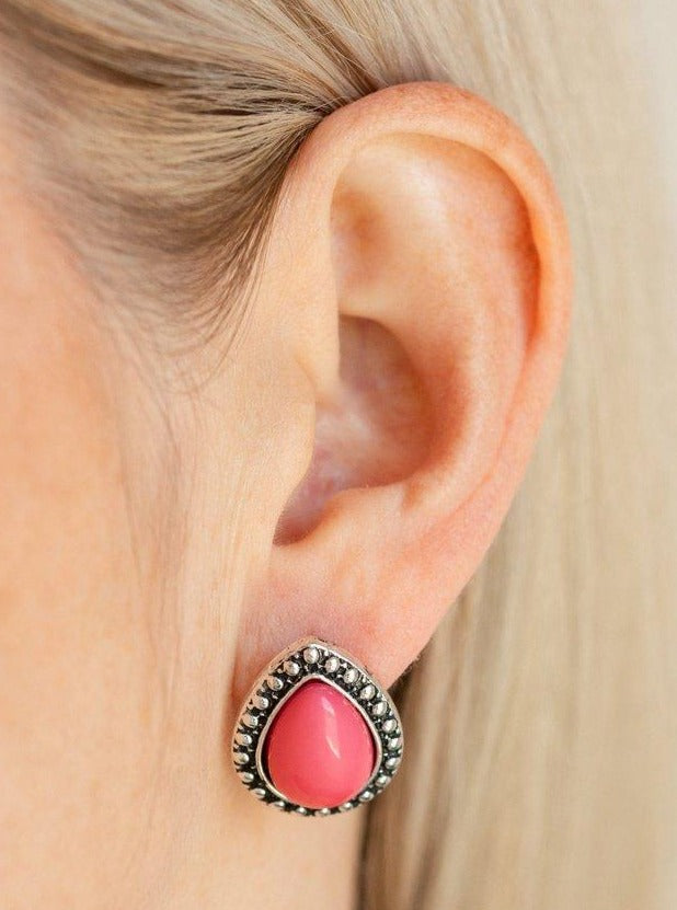 A polished pink teardrop bead is pressed into the center of a studded silver frame for a colorful flair. Earring attaches to a standard post fitting.  Sold as one pair of post earrings.  