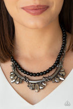Load image into Gallery viewer, A classic strand of black beads and dramatic gunmetal chain drape below the collar. Infused with heavy metal accents, teardrop and marquise cut hematite rhinestone frames connect into a show-stopping fringe. Features an adjustable clasp closure.  Sold as one individual necklace. Includes one pair of matching earrings.  Always nickel and lead free.