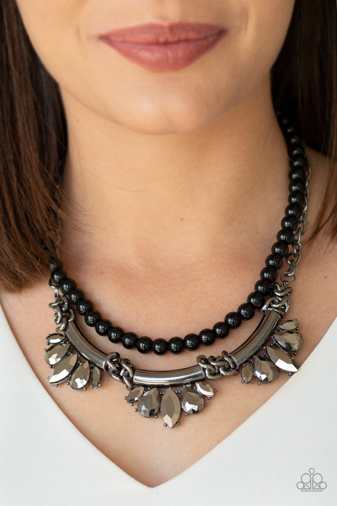 A classic strand of black beads and dramatic gunmetal chain drape below the collar. Infused with heavy metal accents, teardrop and marquise cut hematite rhinestone frames connect into a show-stopping fringe. Features an adjustable clasp closure.  Sold as one individual necklace. Includes one pair of matching earrings.  Always nickel and lead free.