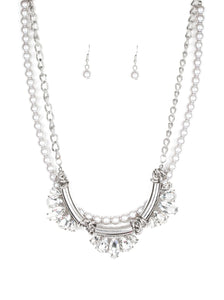 A classic strand of silver pearls and dramatic silvery chain drape below the collar. Infused with heavy metal accents, teardrop and marquise cut white rhinestone frames connect into a show-stopping fringe. Features an adjustable clasp closure.  Sold as one individual necklace. Includes one pair of matching earrings.  