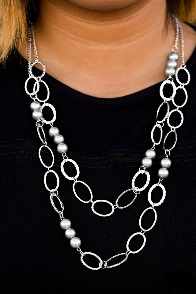 Pearly silver beads and shiny silver ovals featuring smooth, serrated, and hammered finishes link below the collar in two refined layers. Features an adjustable clasp closure.  Sold as one individual necklace. Includes one pair of matching earrings.
