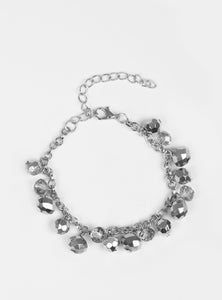 Faceted silver and hematite crystal-like beads swing from a shimmery silver chain, creating a fierce fringe around the wrist. Features an adjustable clasp closure.  Sold as one individual bracelet. 
