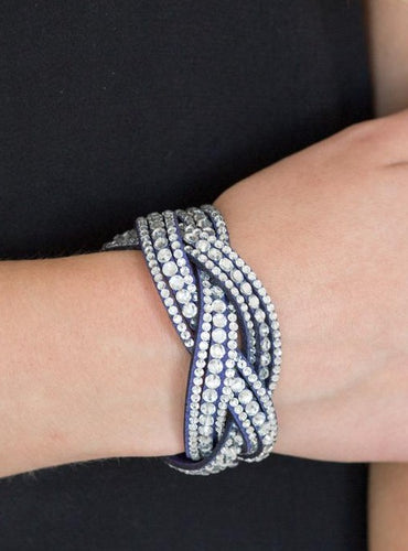 Varying in size, glassy white rhinestones are encrusted along interwoven blue suede bands, creating blinding shimmer across the wrist. Features an adjustable snap closure.  Sold as one individual bracelet.  