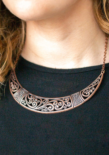 Swirling with ornate filigree filled detail, a shimmery copper crescent plate swings below the collar for a fierce look. Features an adjustable clasp closure.  Sold as one individual necklace. Includes one pair of matching earrings. 