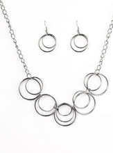 Load image into Gallery viewer, Brushed in an antiqued shimmer, glistening gunmetal hoops link below the collar in a bold industrial fashion. Features an adjustable clasp closure.  Sold as one individual necklace. Includes one pair of matching earrings.