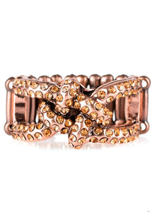 Encrusted in glittery rhinestones, shimmery copper bars crisscross across the finger, coalescing into a bold square knot atop the finger. Features a stretchy band for a flexible fit.  Sold as one individual ring.