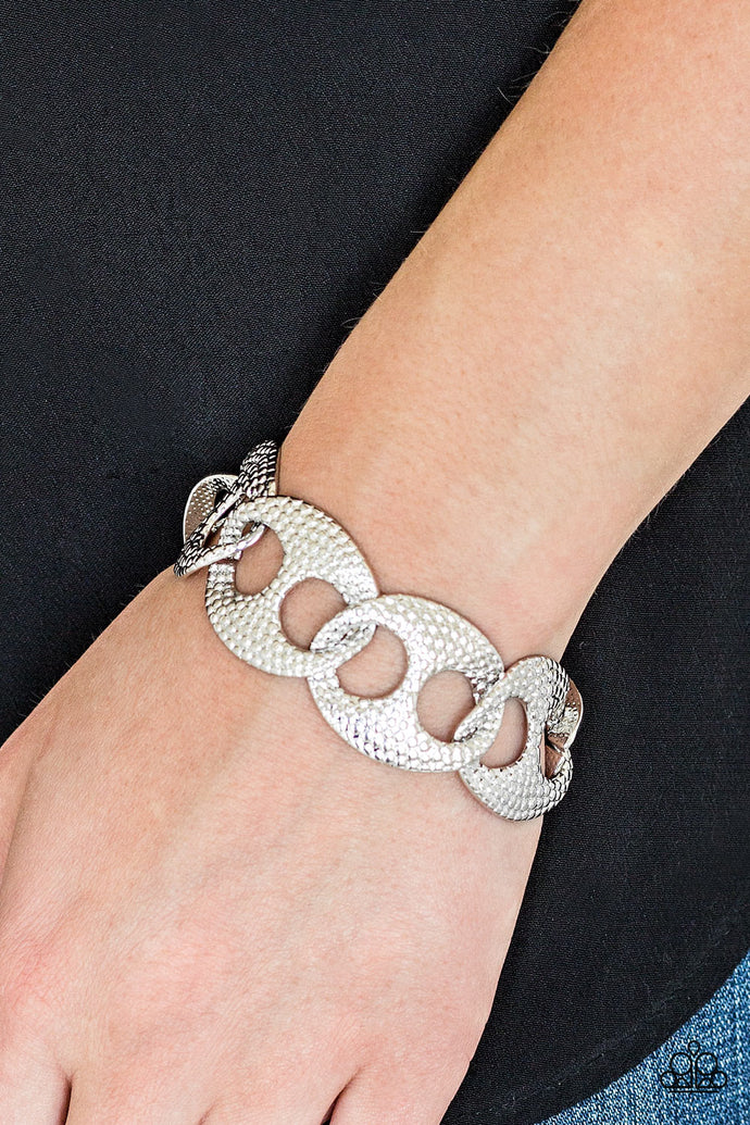 Embossed in shimmery circular patterns, asymmetrical silver frames link across the wrist for a casually industrial look. Features an adjustable clasp closure.  If you have a larger wrist this one is a shoe in for you!    Sold as one individual bracelet.  Always nickel and lead free.