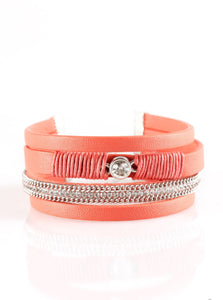 Coral leather strands layer across the wrist. Infused with silver chain and white rhinestone accents, coral cording knots around a leather strand, securing a solitaire white rhinestone in place for a whimsical finish. Features an adjustable clasp closure.  Sold as one individual bracelet.
