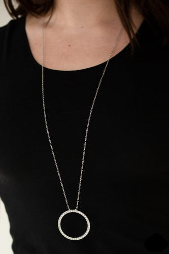 Encrusted in glittery white rhinestones, a dramatic silver hoop swings from the bottom of a lengthened silver chain for a refined look. Features an adjustable clasp closure.  Sold as one individual necklace. Includes one pair of matching earrings. 