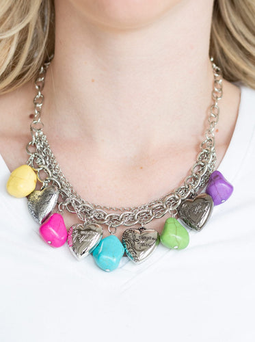 Multicolored faux rocks alternate with heart charms along a chunky silver chain. Hearts are inscribed with the phrase 