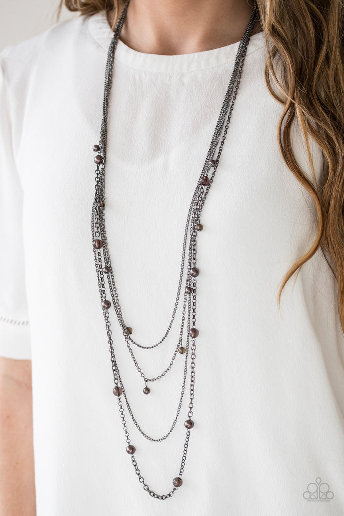 Varying in shape and shimmer, four glistening gunmetal chains drape across the chest. Glassy and pearly metallic beading alternate along the shimmery layers for a refined finish. Features an adjustable clasp closure.  Sold as one individual necklace. Includes one pair of matching earrings.   