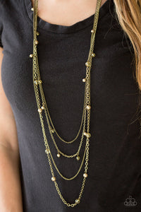 Varying in shape and shimmer, four glistening brass chains drape across the chest. Glassy and pearly brass beading alternate along the shimmery layers for a refined finish. Features an adjustable clasp closure.  Sold as one individual necklace. Includes one pair of matching earrings.