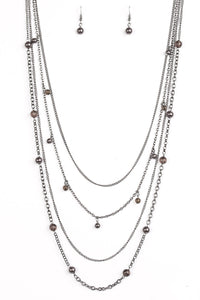 Varying in shape and shimmer, four glistening gunmetal chains drape across the chest. Glassy and pearly metallic beading alternate along the shimmery layers for a refined finish. Features an adjustable clasp closure.  Sold as one individual necklace. Includes one pair of matching earrings.