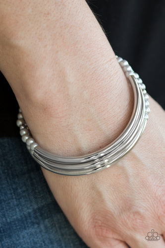 Shiny silver bars and pearly silver beads are threaded along stretchy elastic bands, creating refined layers across the wrist.  Sold as one set of three bracelets.  Always nickel and lead free.