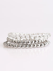 Classic silver beads and faceted white beading are threaded along three stretchy bands, creating refined layers across the wrist in a sleek fashion.  Sold as one set of three bracelets.