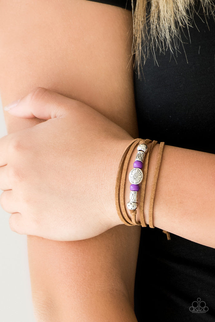 An array of purple and silver beads are knotted in place along elongated suede cording for a wanderlust fashion. To secure bracelet, tie ends in place around the wrist at desired length.  Sold as one individual bracelet.  Always nickel and lead free.