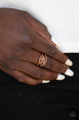 Radiating with topaz rhinestones, two rows of glittering copper bars arc across the finger. Two pearly copper beads are pressed into the center of a roof rhinestones that wrap around each bead, adding a dramatically refined finish to the piece. Features a dainty stretchy band for a flexible fit.  Sold as one individual ring.  Always nickel and lead free.