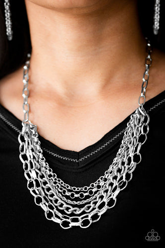 Mismatched silver chains layer below the collar for a bold industrial look. Painted in a neutral finish, a shiny gray chain drapes between the shimmery silver chains for a vivacious finish. Features an adjustable clasp closure.  Sold as one individual necklace. Includes one pair of matching earrings.  Always nickel and lead free.