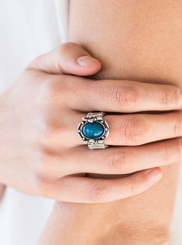 A polished blue bead is pressed into the center of a silver frame blooming with floral details for a whimsical finish. Features a stretchy band for a flexible fit.  Sold as one individual ring.  