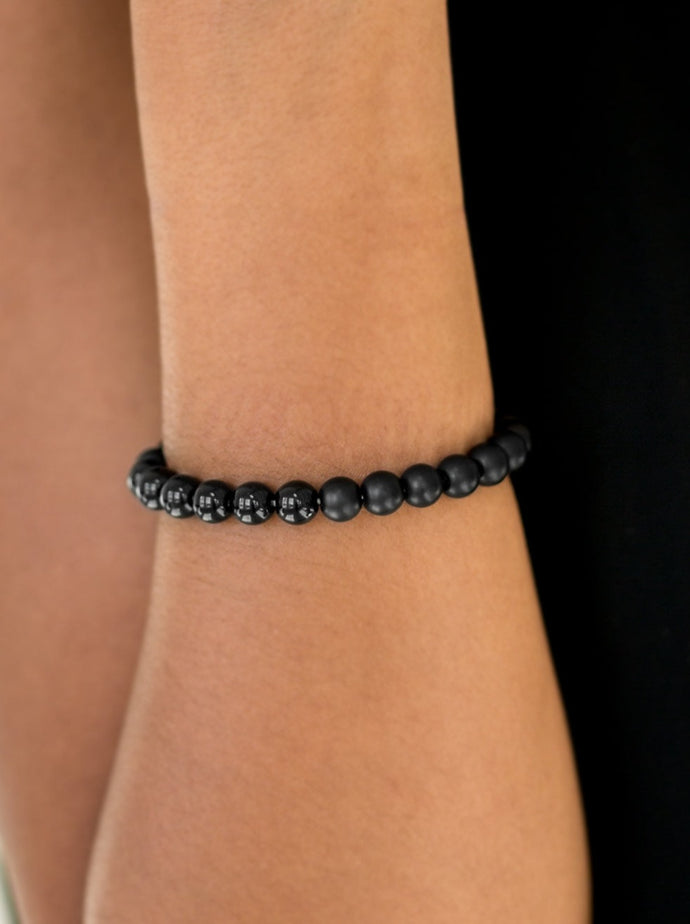 Brushed in a matte finish, glassy black beads are threaded along a stretchy elastic band for a seasonal look. A section of beads is brushed in a shiny finish for an earthy look.  Sold as one individual bracelet.  