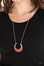 Load image into Gallery viewer, Gradually increasing in size towards the center, dainty orange beads are encrusted along the center of a silver crescent frame. Robust orange beads flare out from the bottom of the shimmery silver frame, creating a bold stationary pendant at the bottom of an elongated silver chain. Features an adjustable clasp closure.  Sold as one individual necklace. Includes one pair of matching earrings.  Always nickel and lead free.