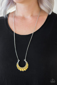 Gradually increasing in size towards the center, dainty yellow beads are encrusted along the center of a silver crescent frame. Yellow beads flare out from the bottom of the shimmery silver frame, creating a bold stationary pendant at the bottom of an elongated silver chain.