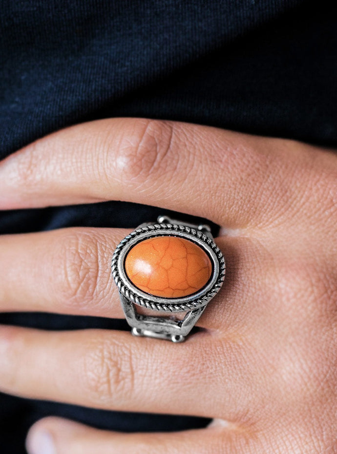 An orange stone is pressed into the center of a shimmery silver frame radiating with rustic texture. Features a stretchy band for a flexible fit.  Sold as one individual ring.