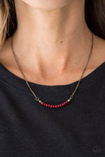 Load image into Gallery viewer, Faceted red beading is threaded along a skinny wire, creating a dainty pendant below the collar. The colorful pendant swings from the bottom of a glistening brass chain for a rustic finish. Features an adjustable clasp closure.  Sold as one individual necklace. Includes one pair of matching earrings.  Always nickel and lead free.