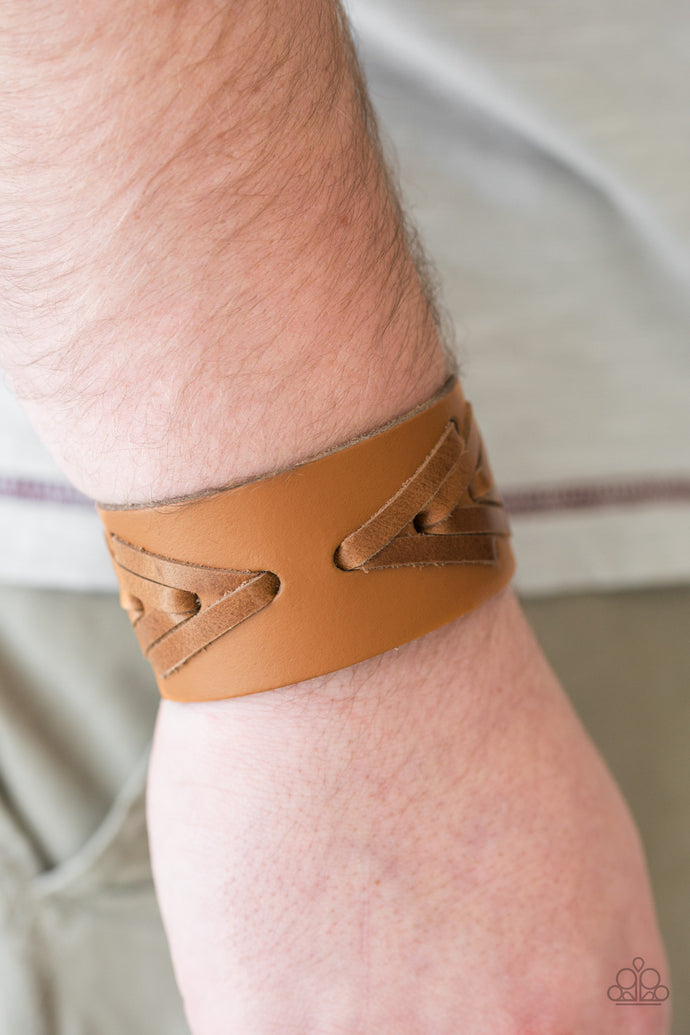 Strips of distressed leather laces are stitched across the front of a leather band, creating a rugged geometric pattern around the wrist. Features an adjustable snap closure.  Sold as one individual bracelet.  Always nickel and lead free.