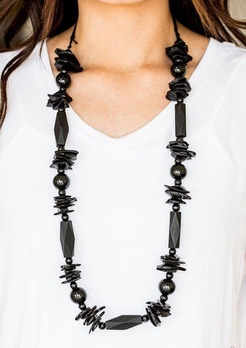 Featuring round, faceted, and distressed finishes, mismatched black wooden beads are threaded along shiny black cording for a summery look. Features an adjustable sliding knot closure.   Sold as one individual necklace. Includes one pair of matching earrings.  Always nickel and lead free.