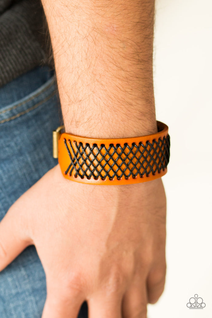 Shiny black thread is stitched across the front of a brown leather band. The crisscrossing threads create a tactile pattern around the wrist. Features an adjustable buckle closure.  Sold as one individual bracelet.  Always nickel and lead free.