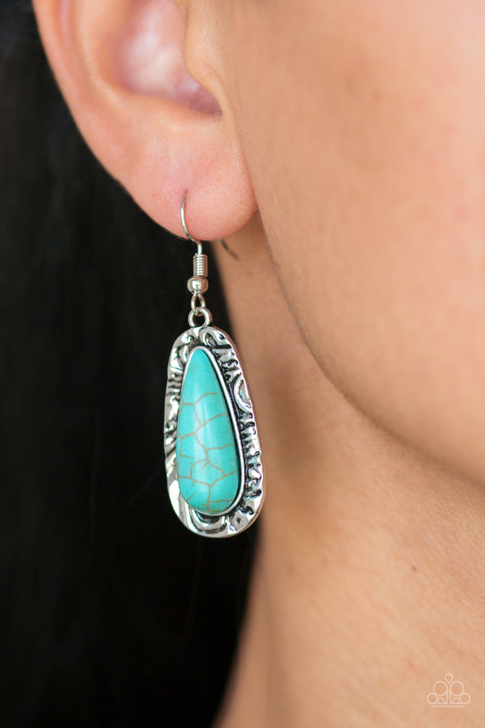 Chiseled into a tranquil teardrop, a refreshing turquoise stone is pressed into the center of a shimmery silver frame radiating with hammered details for an artisan inspired look. Earring attaches to a standard fishhook fitting.  Sold as one pair of earrings.  Always nickel and lead free.