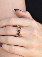 Load image into Gallery viewer, Encrusted in dainty topaz rhinestones, a trio of copper daisies connect across the finger, creating a whimsical band. Features a dainty stretchy band for a flexible fit.  Sold as one individual ring.