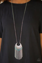 Load image into Gallery viewer, Etched in geometric patterns, a silver crescent swings from the bottom of an elongated silver chain. The tribal inspired pendant gives way to a shimmery fringe sprinkled with shiny blue beads for a seasonal finish. Features an adjustable clasp closure.  Sold as one individual necklace. Includes one pair of matching earrings.