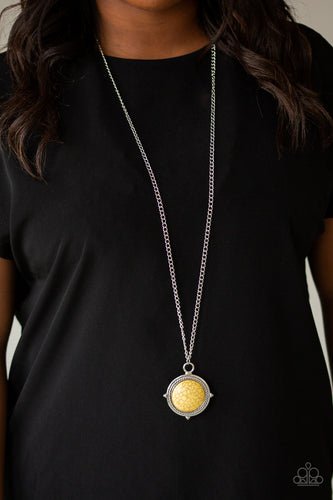 A smooth yellow stone is pressed into a shimmery silver frame radiating with metallic rope-like texture, creating a bold pendant at the bottom of a lengthened silver chain. Features an adjustable clasp closure.  Sold as one individual necklace. Includes one pair of matching earrings.  Always nickel and lead free.