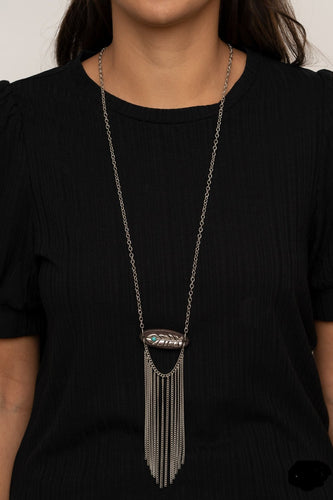 A fringe of silver chains swings from the bottom of a wooden frame adorned with a shimmery silver feather charm. Dotted with a refreshing turquoise stone, the whimsical pendant attaches to a lengthened silver chain for a free-spirited finish. Features an adjustable clasp closure.  Sold as one individual necklace. Includes one pair of matching earrings.  Always nickel and lead free.