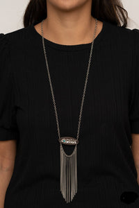 A fringe of silver chains swings from the bottom of a wooden frame adorned with a shimmery silver feather charm. Dotted with a refreshing turquoise stone, the whimsical pendant attaches to a lengthened silver chain for a free-spirited finish. Features an adjustable clasp closure.  Sold as one individual necklace. Includes one pair of matching earrings.  Always nickel and lead free.
